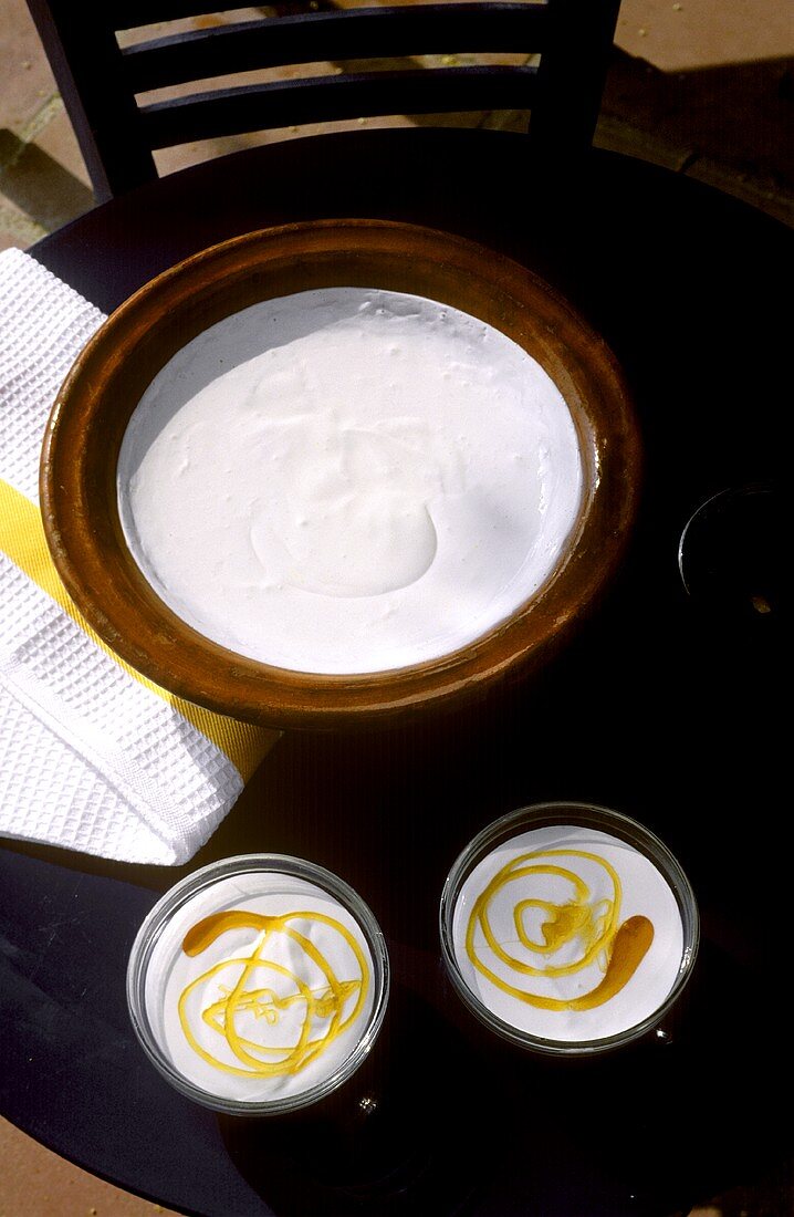 Yoghurt in dish and two bowls of yoghurt with honey
