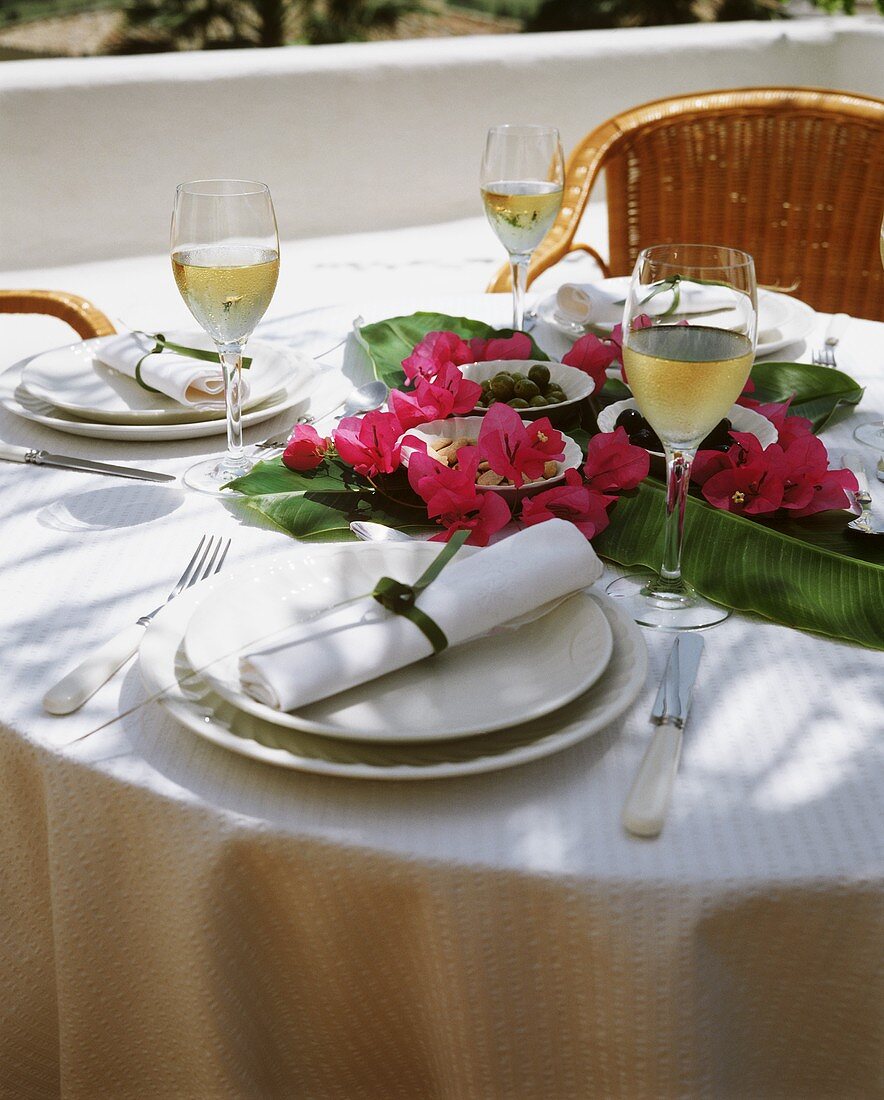 Gedeckter Tisch mit Tapas auf Bananenblättern & Blüten