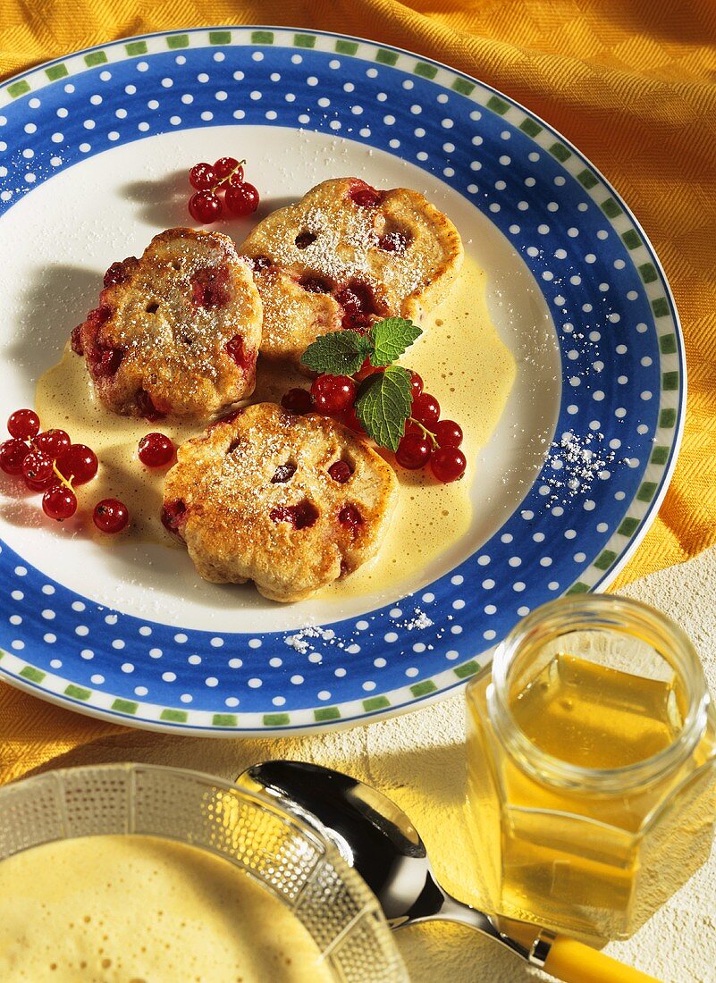 Redcurrant buns with cinnamon sauce and icing sugar