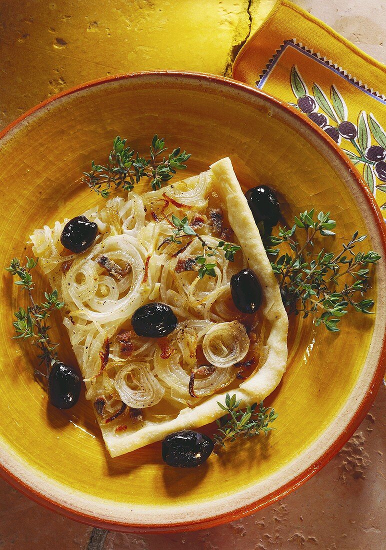 Onion pizza with black olives, anchovies and thyme