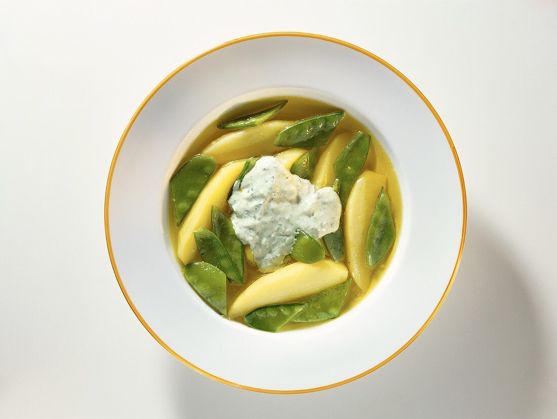 Potato soup with mangetouts and  sour cream with basil