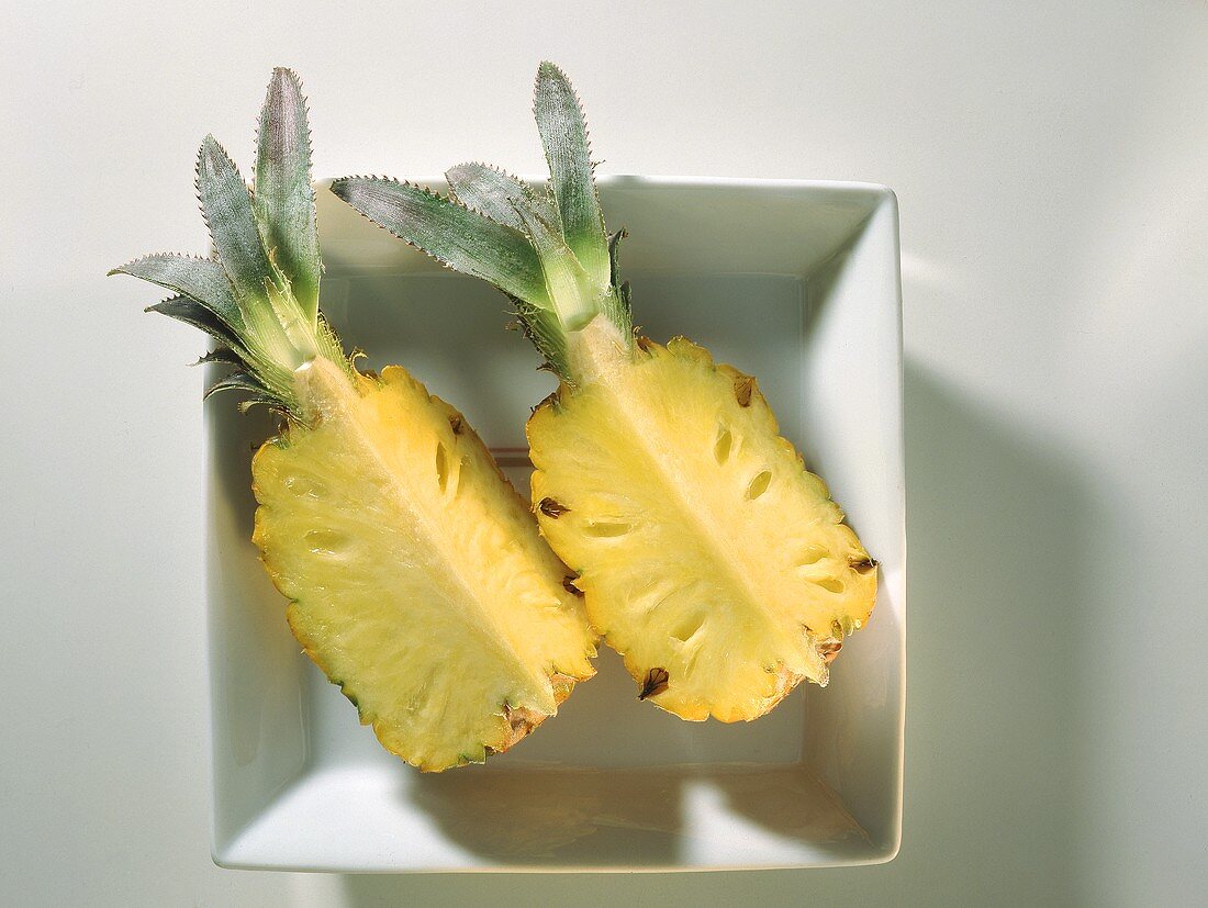 Zwei frische Ananashälften in weißem Schälchen