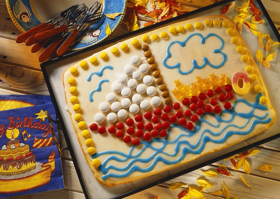 Kuchen mit Segelboot-Bild aus Süssigkeiten & Gummibärchen