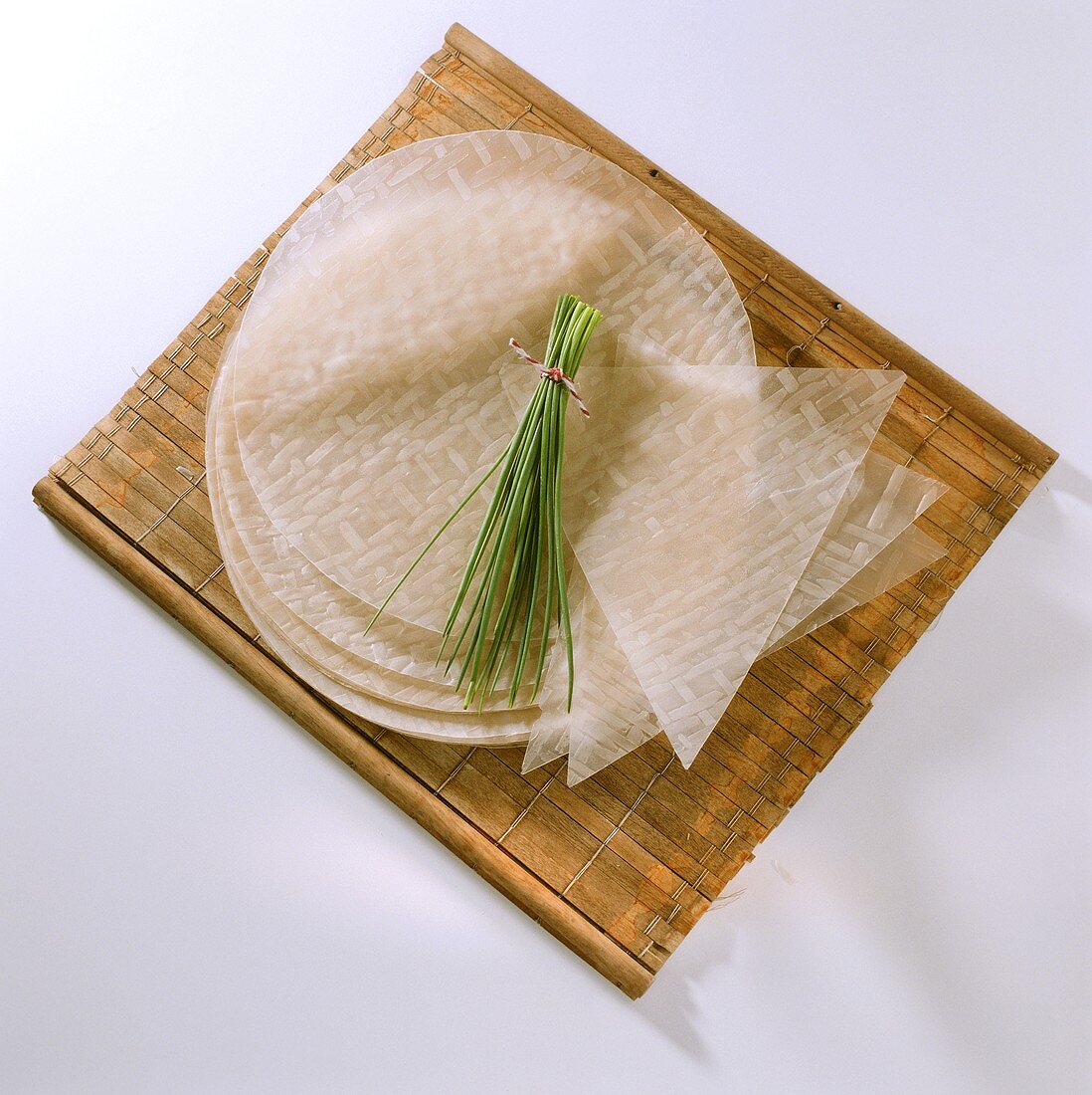 Rundes & dreieckiges Reispapier, darauf Bund Schnittlauch