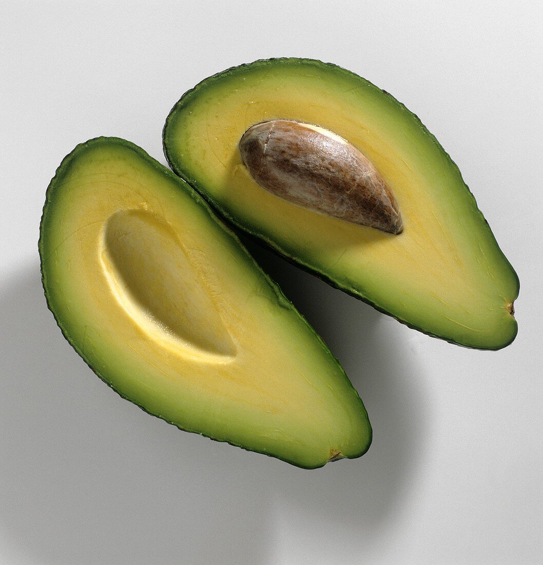 Two avocado halves with and without stone