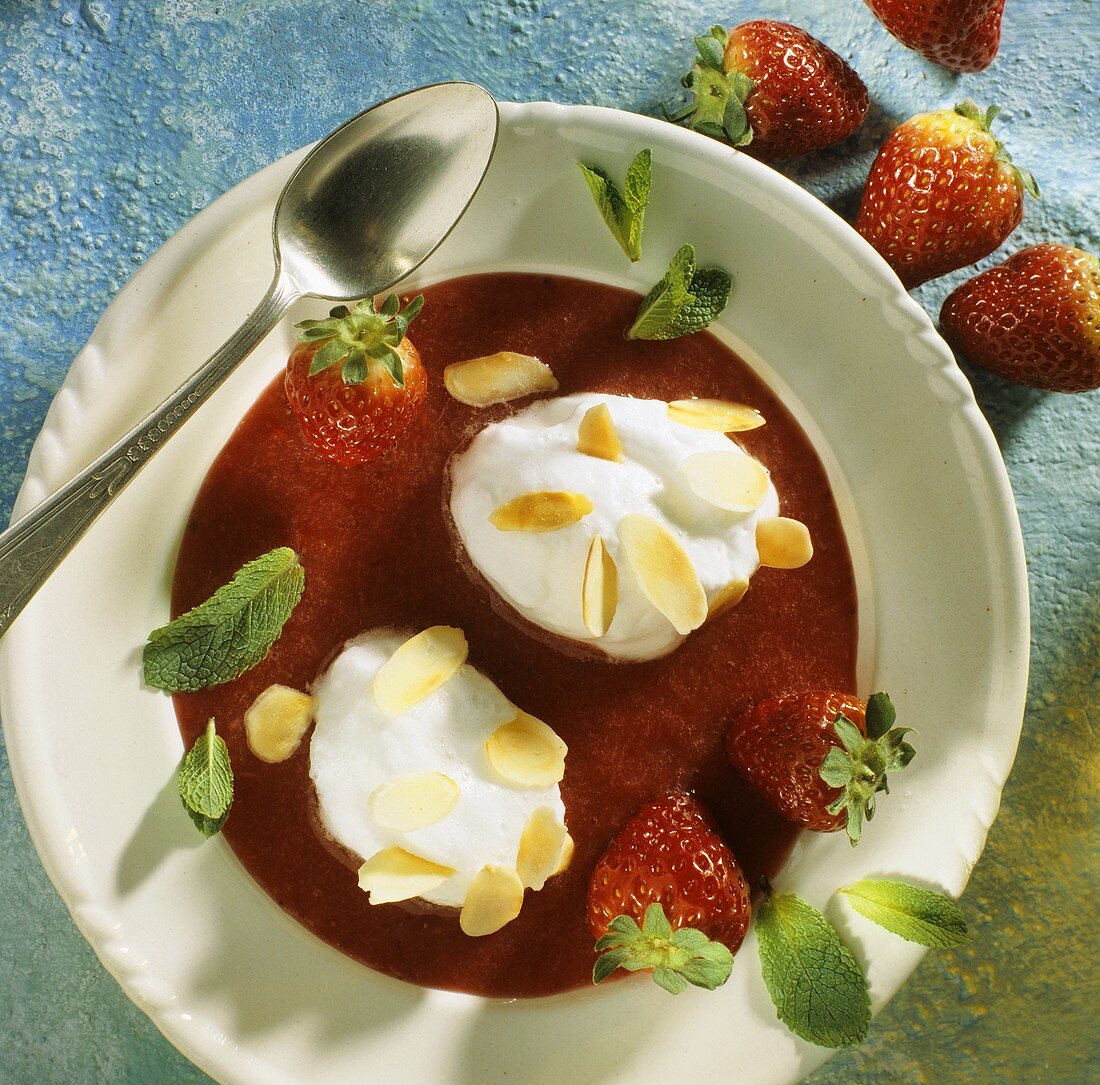 Poached meringues with flaked almonds, mint on strawberry sauce