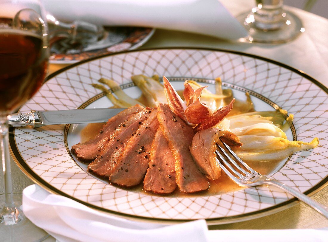 Pink sliced roast duck breast with chicory & radicchio