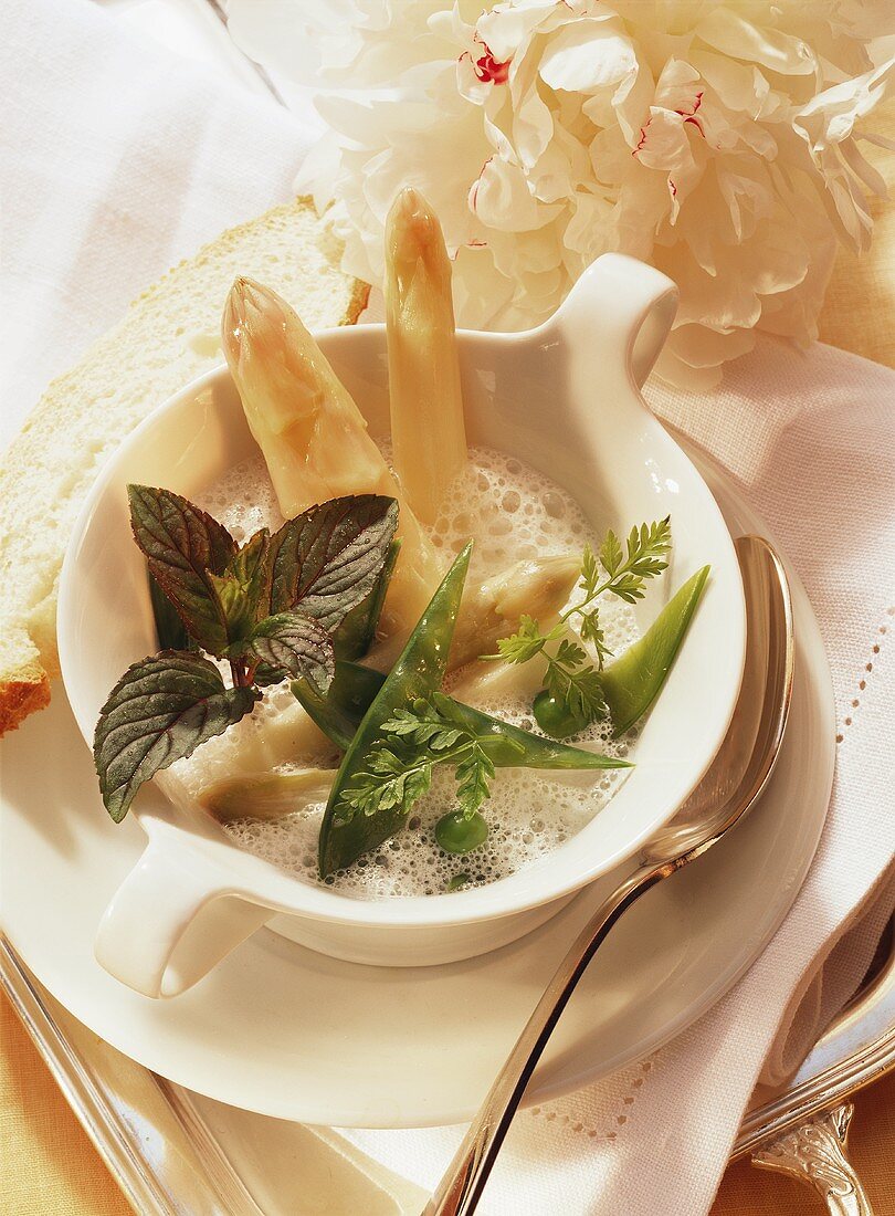 White asparagus cream soup with mangetouts, peas & mint