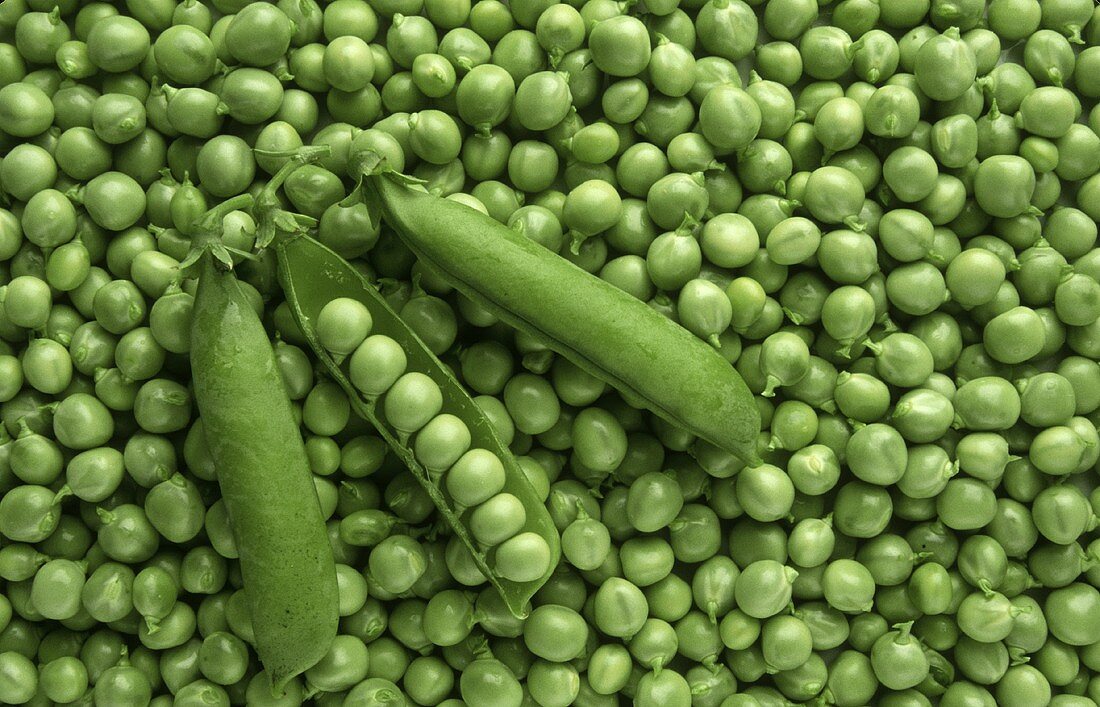 Shelled peas, with three pods on top 
