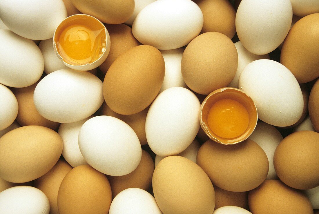 Viele braune & weiße Eier, darunter zwei aufgeschlagene