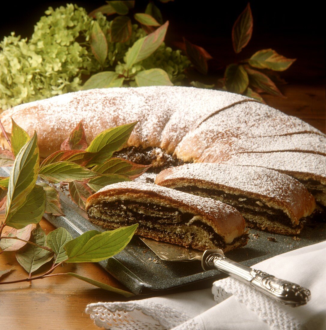 Poppy seed strudel with icing sugar on the baking sheet