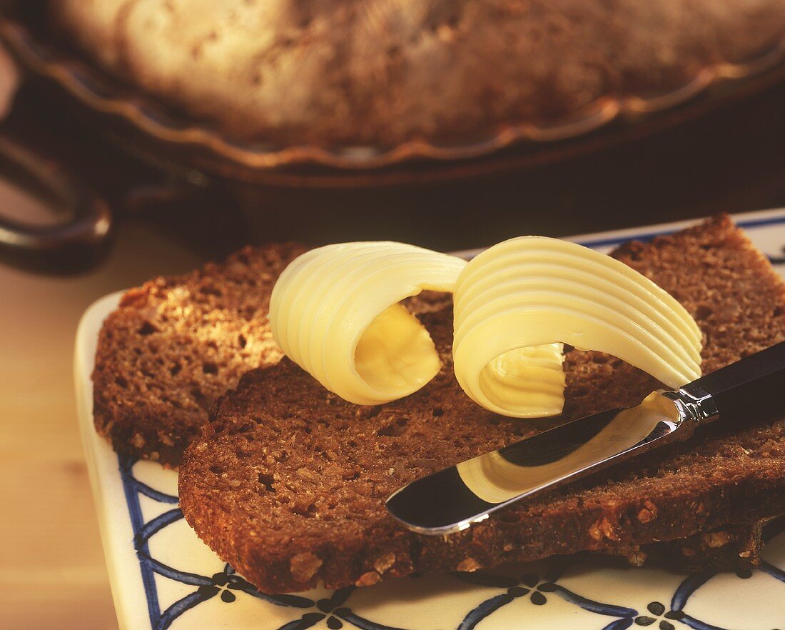 Rye bread slices with butter rolls and butter knife