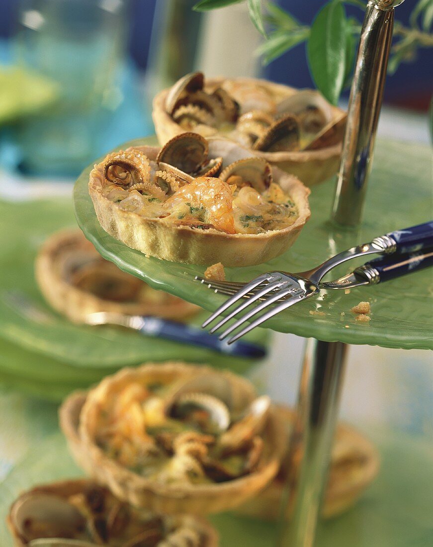 Mini-quiches with seafood on tiered stand with forks