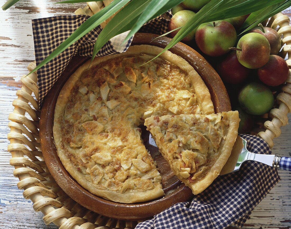 Apple and onion quiche with bacon in baking dish