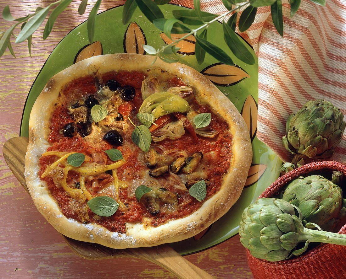 Pizza quattro stagioni with oregano leaves
