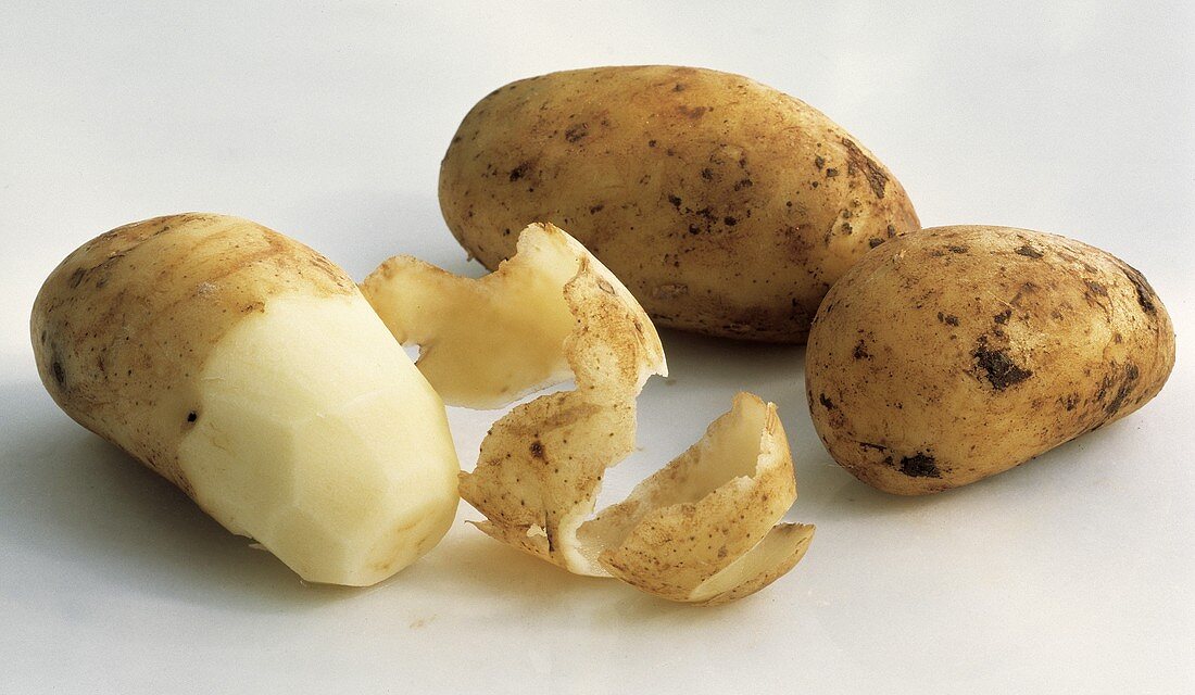 Zwei ungeschälte Kartoffeln & eine halb geschälte Kartoffel