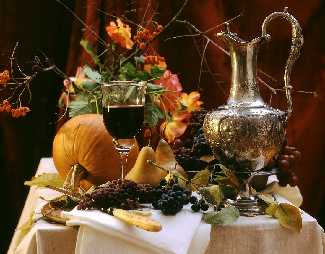 Herbstliches Stillleben mit Trauben, Birnen, Kürbis & Rotwein