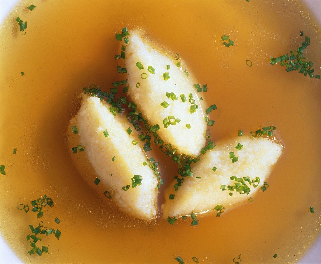 Semolina dumplings (detail) in clear broth with snipped chives