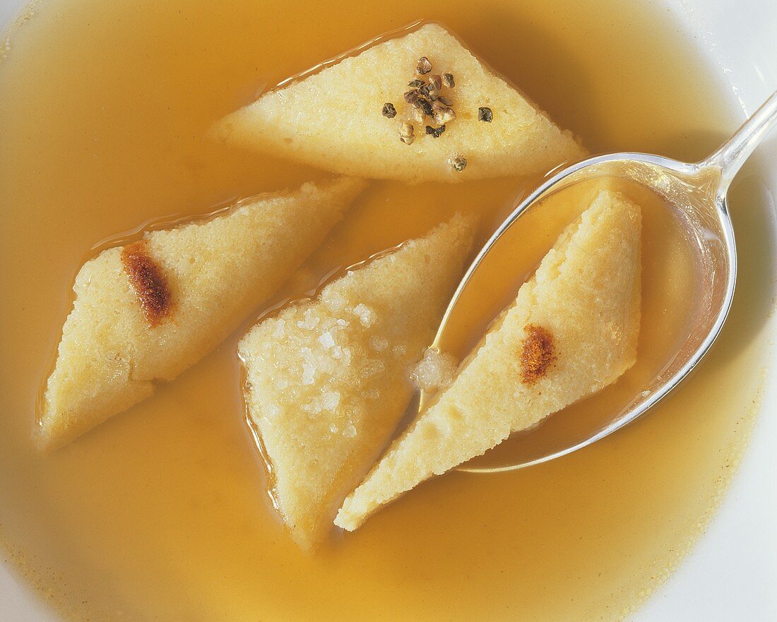 Vienna cheese dumplings as soup addition in broth with spoon