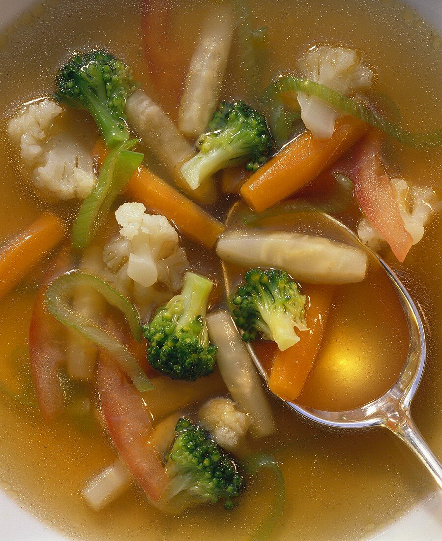 Vegetables (detail) in clear broth with spoon