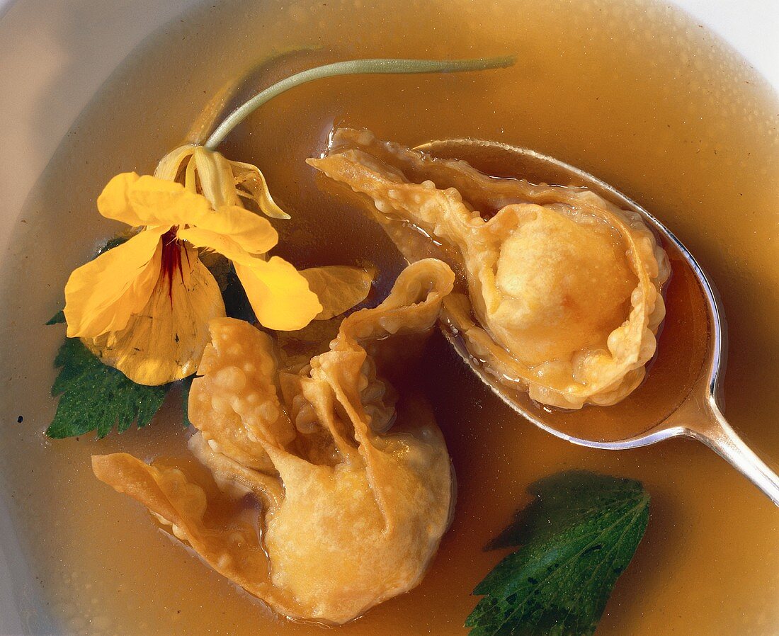 Won tons (pastry parcels) in broth with parsley & flower