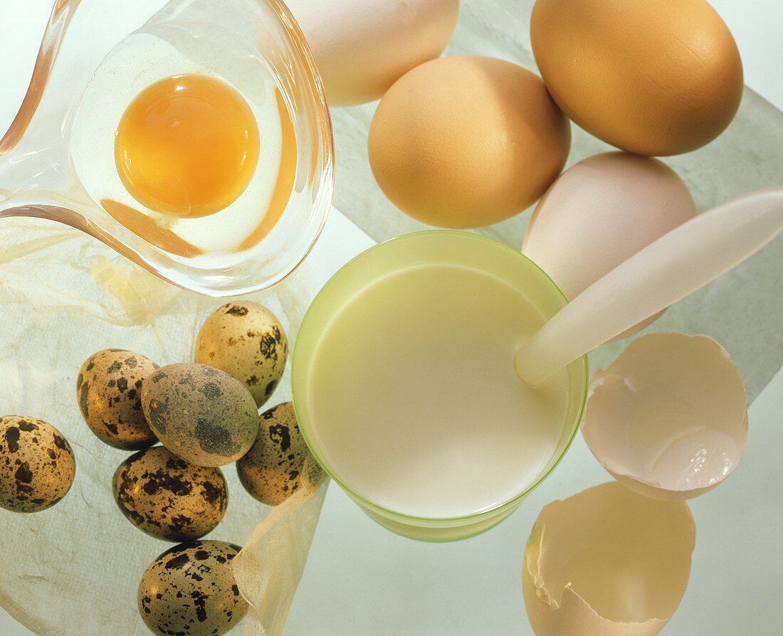 Whole eggs, a broken egg, quail's eggs & a beaker of milk