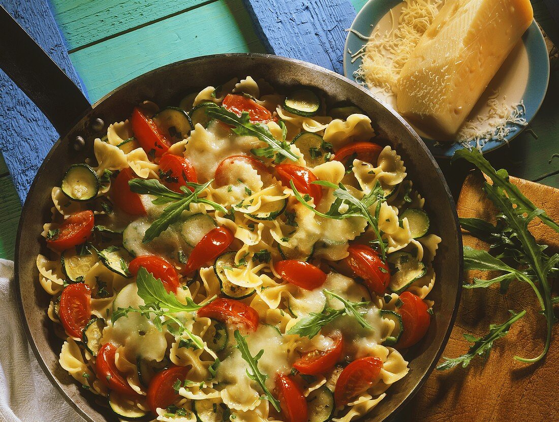 Courgette farfalle with cherry tomatoes & rocket in pan