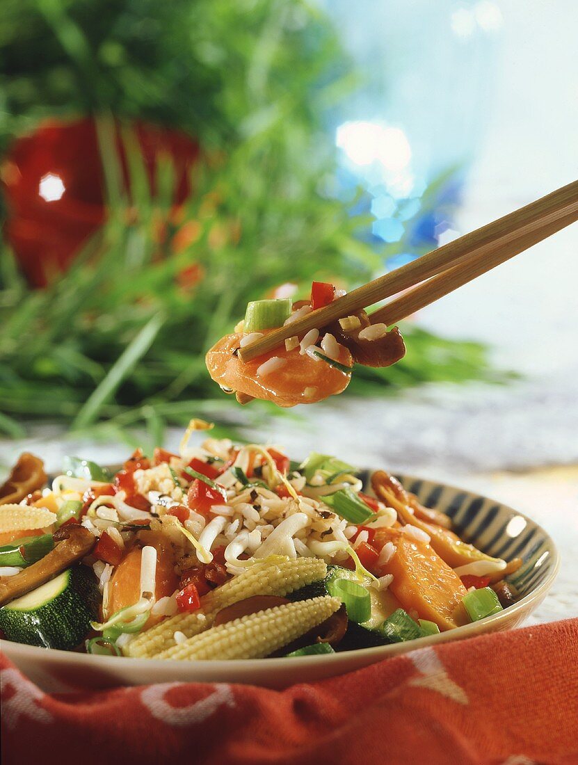 Korean rice with vegetables & mushrooms (chopsticks above plate)