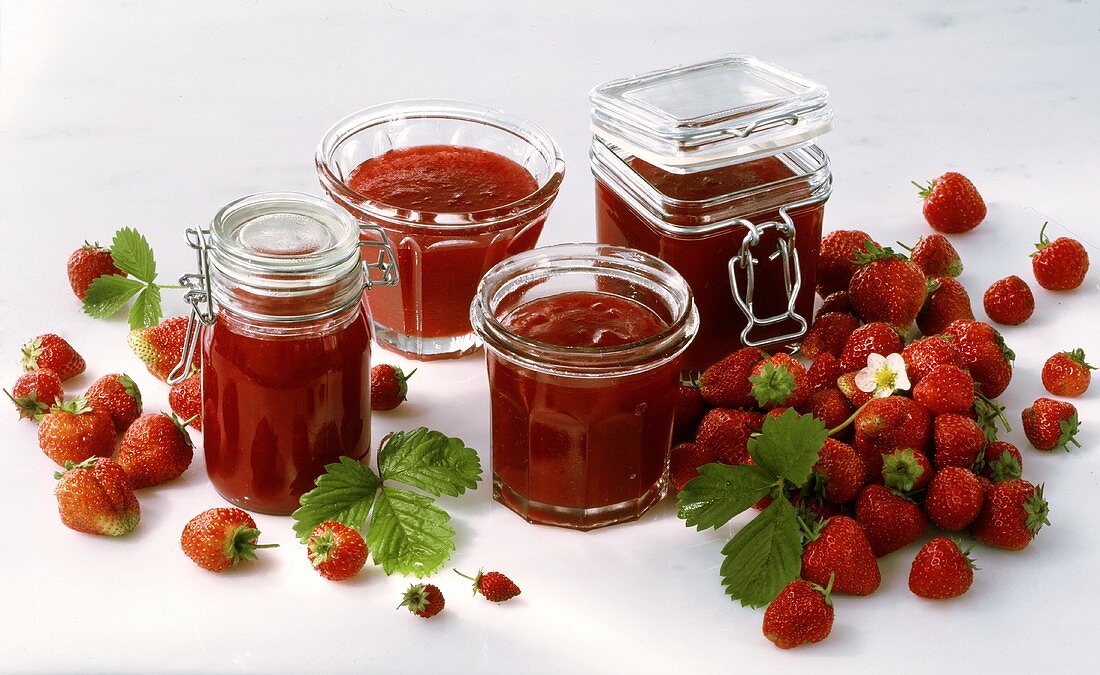 Strawberries and jars of strawberry jam