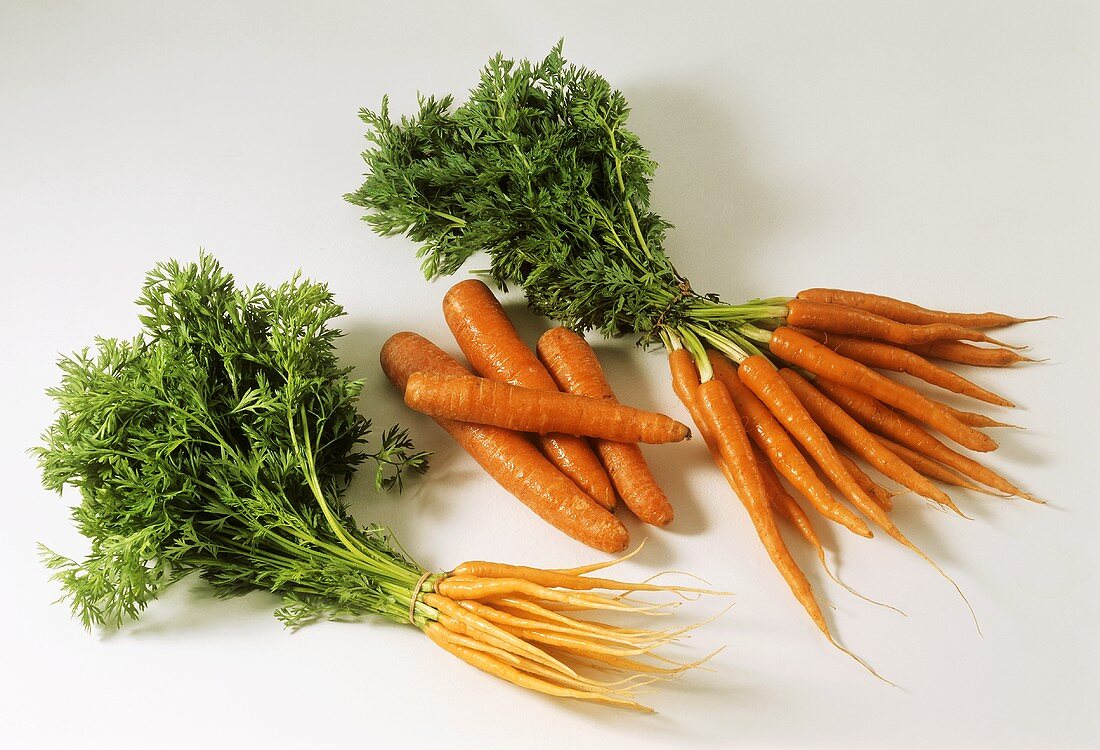 Young carrots, two bunches with leaves, & single carrots without