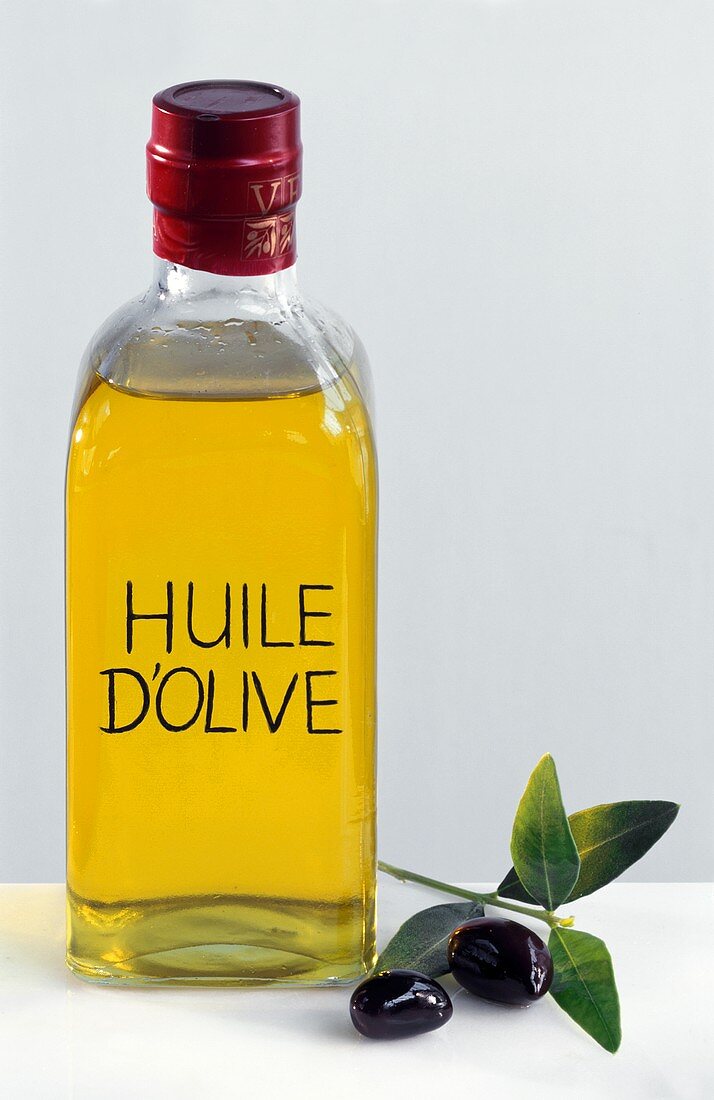Flasche Olivenöl mit Aufschrift Olive Oil und schwarze Oliven