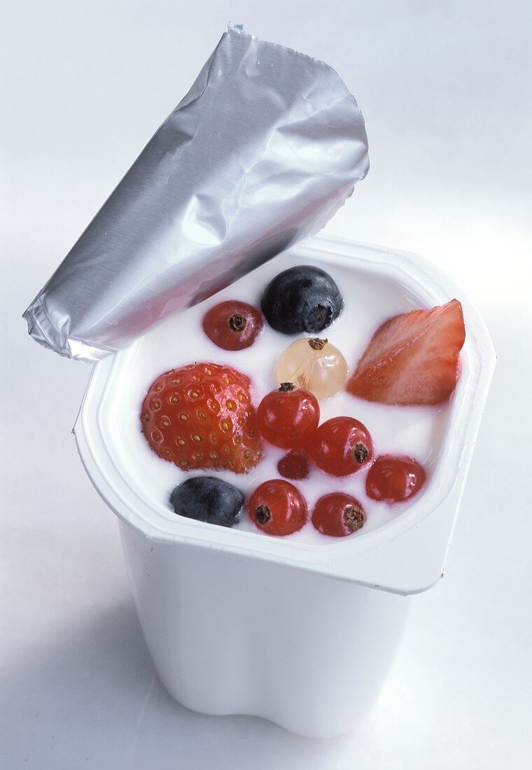Yoghurt with various berries in opened pot