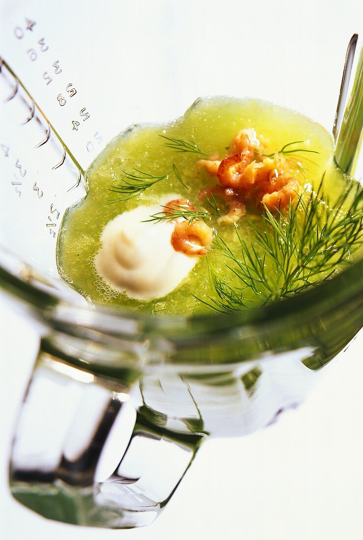 Chilled cucumber soup with dill, shrimps in glass measuring jug