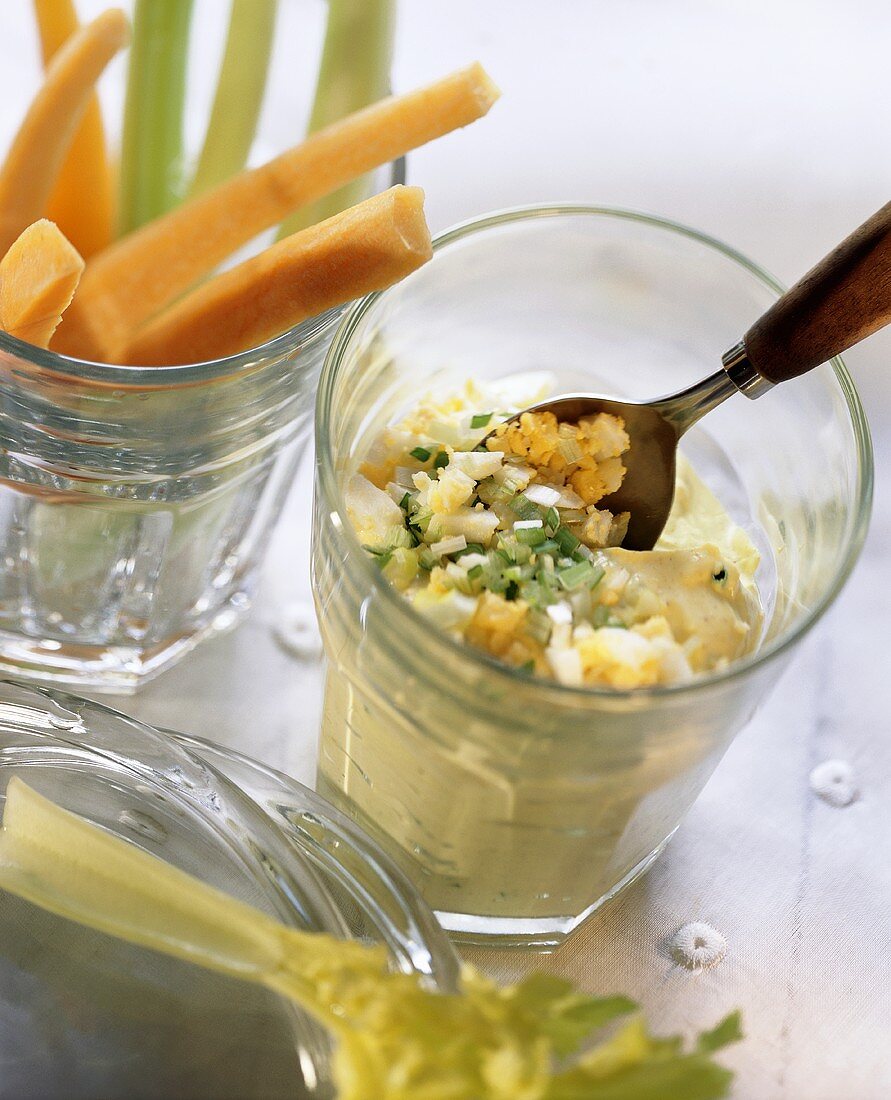 Curry quark with chopped egg; vegetables sticks in glasses