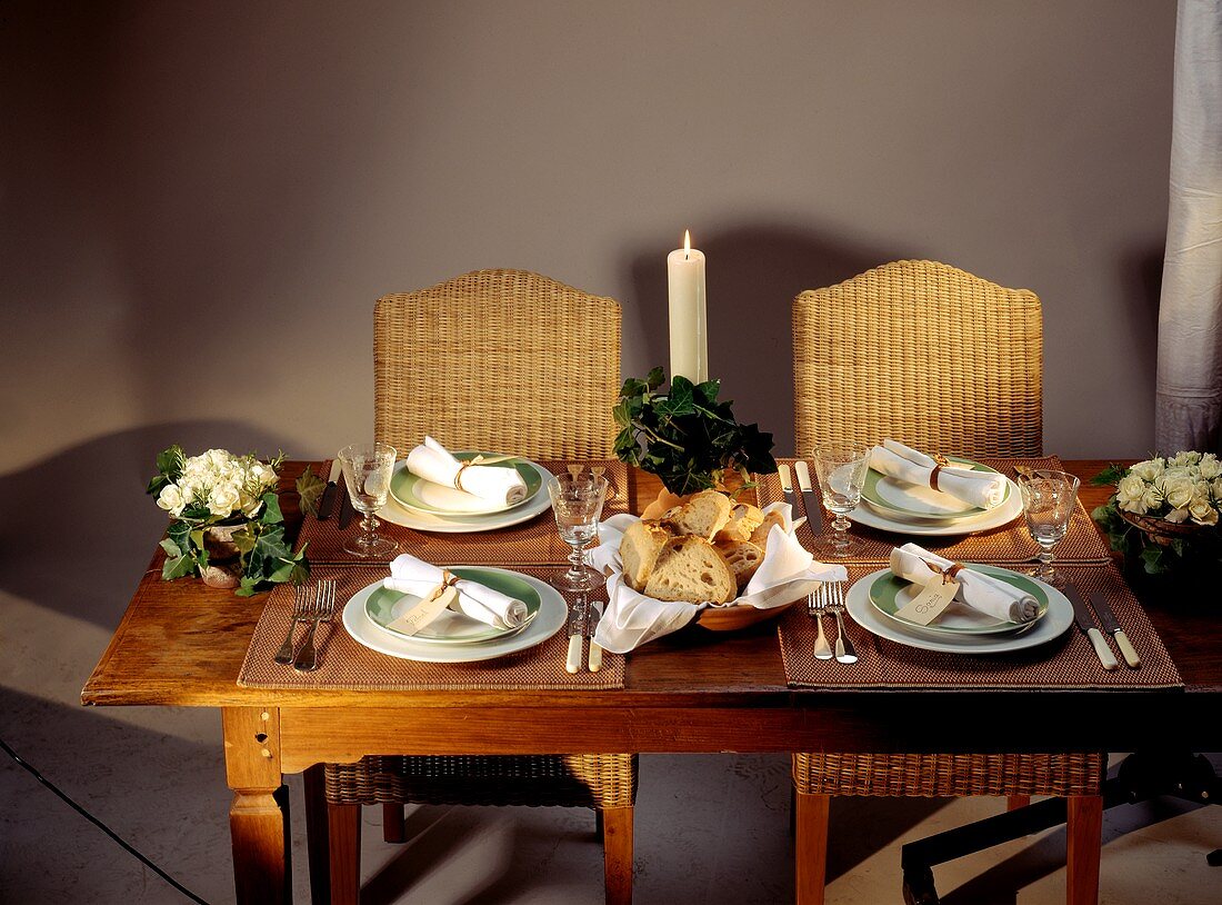 Gedeckter Tisch mit Tellern, Servietten und brennender Kerze