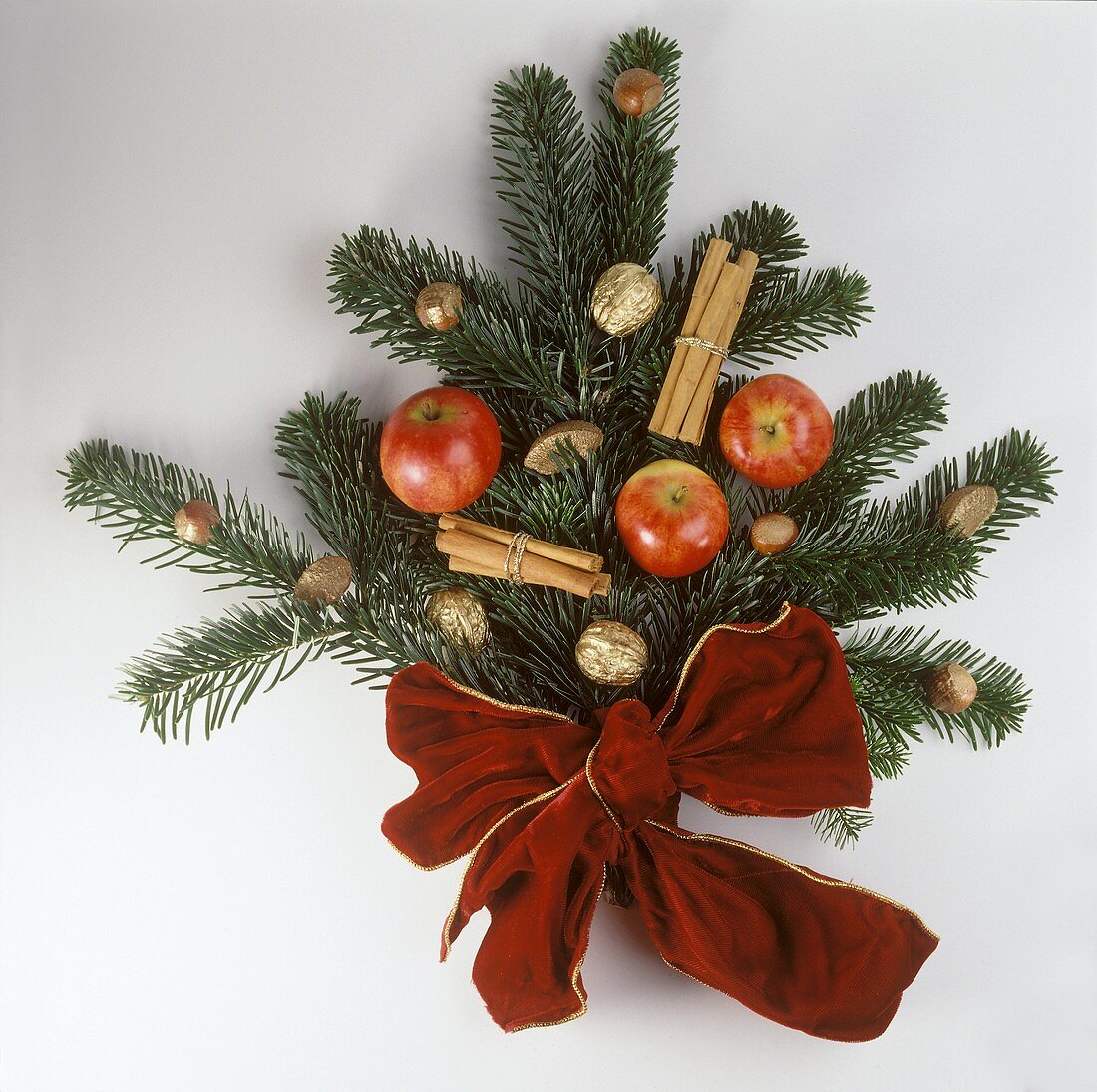 Weihnachtliche Deko aus Tannenzweigen, Äpfeln, Goldnüssen etc