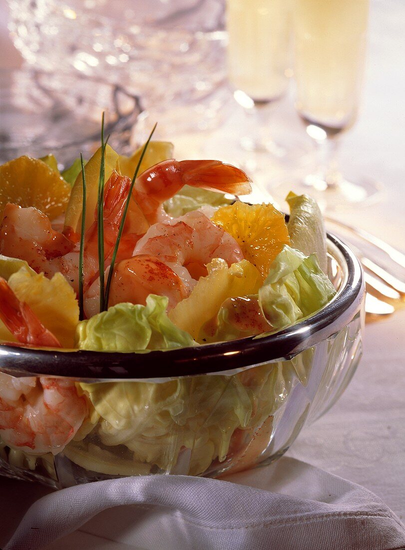 Lettuce with shrimps and oranges in glass dish