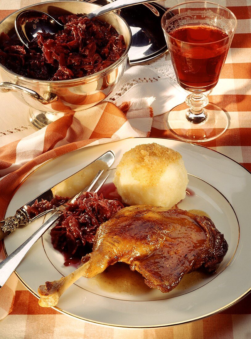 Martinmas goose with red cabbage & dumpling; glass of red wine