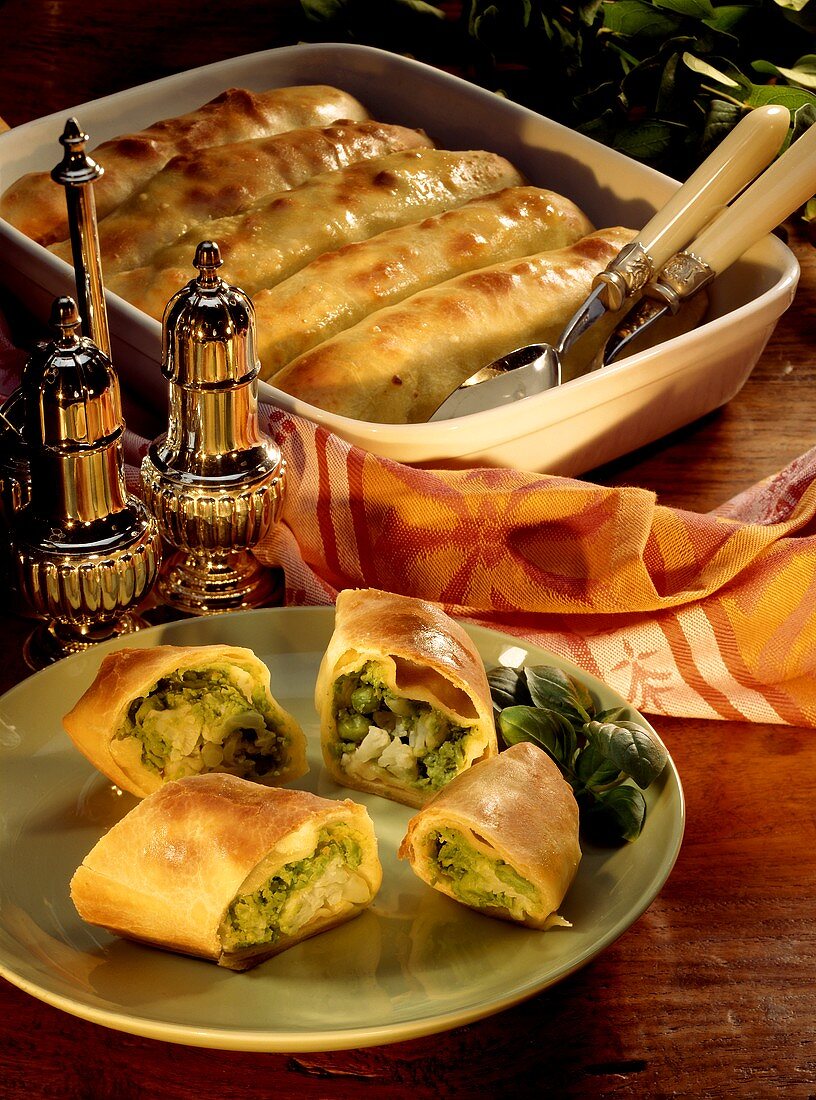 Pasta and vegetable rolls on plate and in baking dish