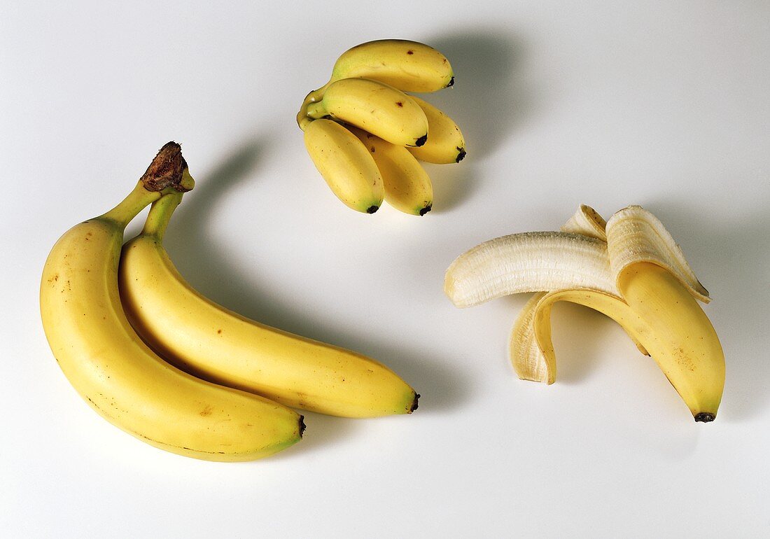 Two whole bananas, one half-peeled banana & baby bananas