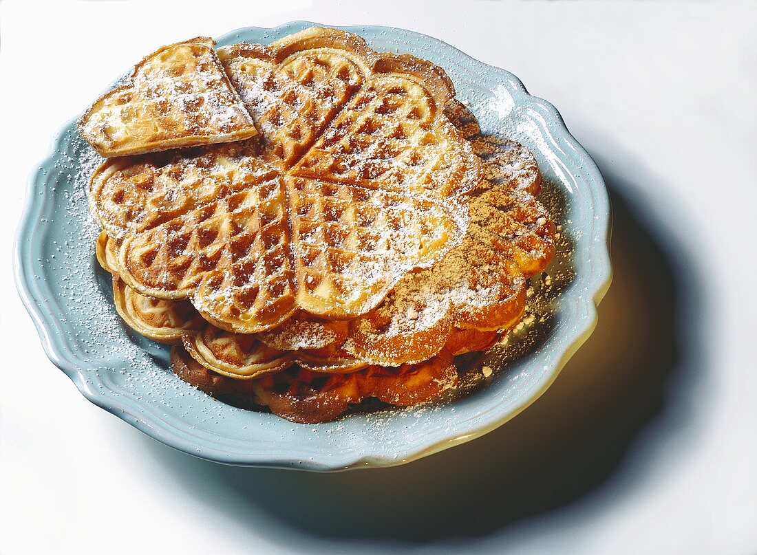 Egg waffle hearts with icing sugar on plate