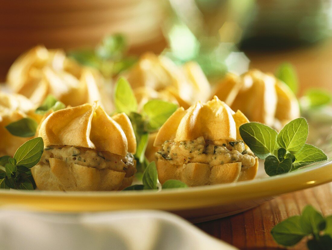 Mini-Windbeutel mit Kartoffelcreme auf Teller mit Oregano