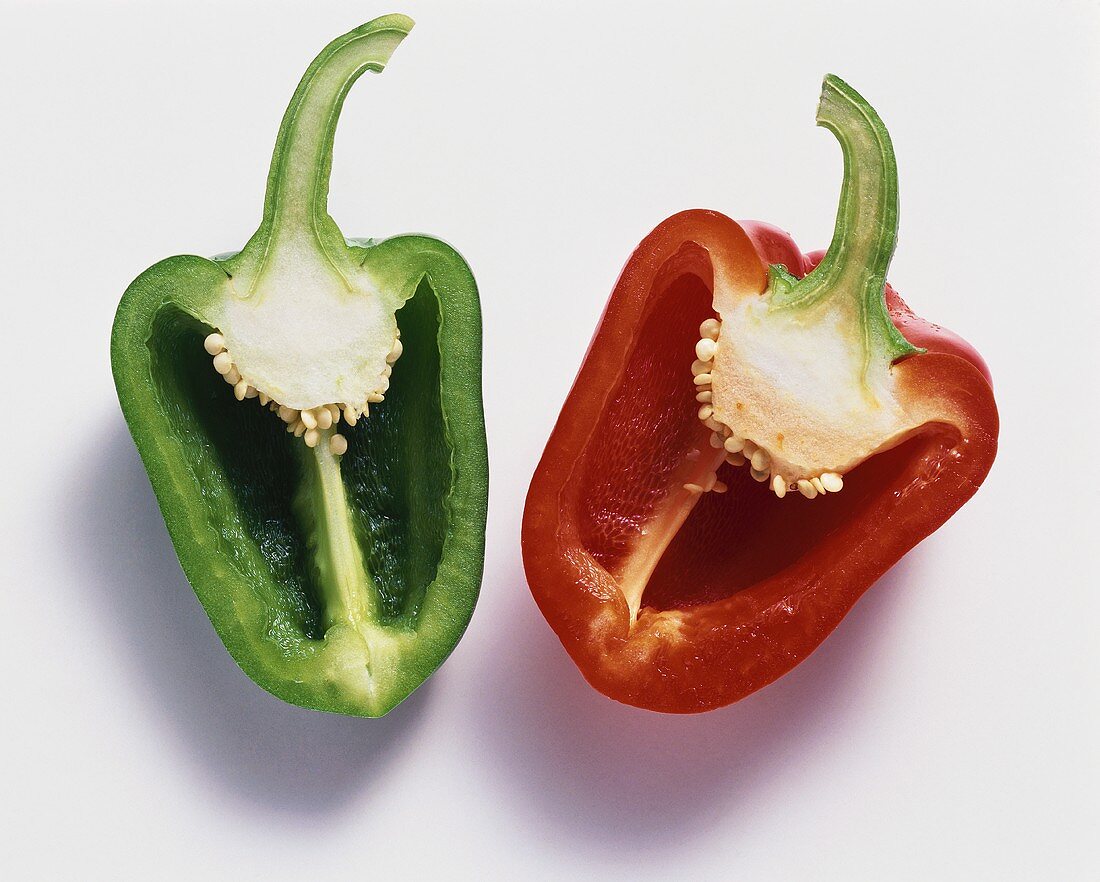 Half a red and green pepper on white background