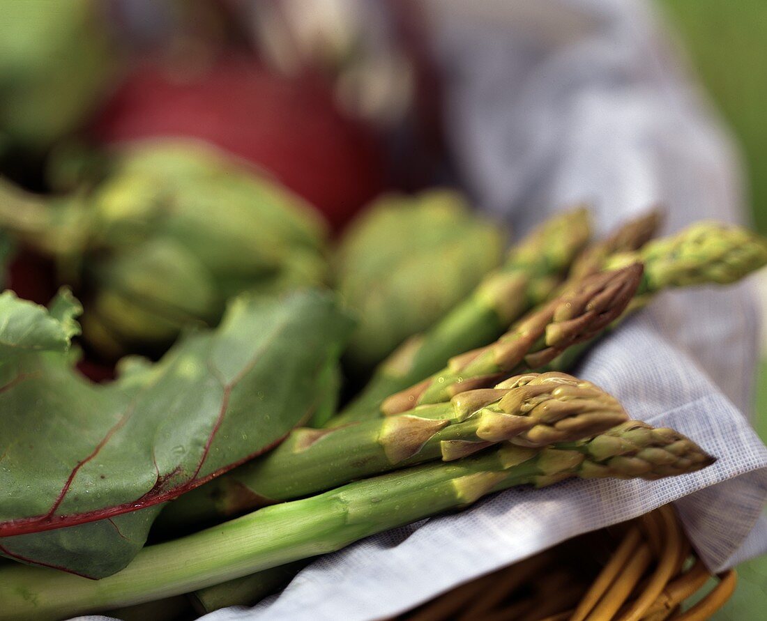 Fresh green asparagus & other vegetables in basket