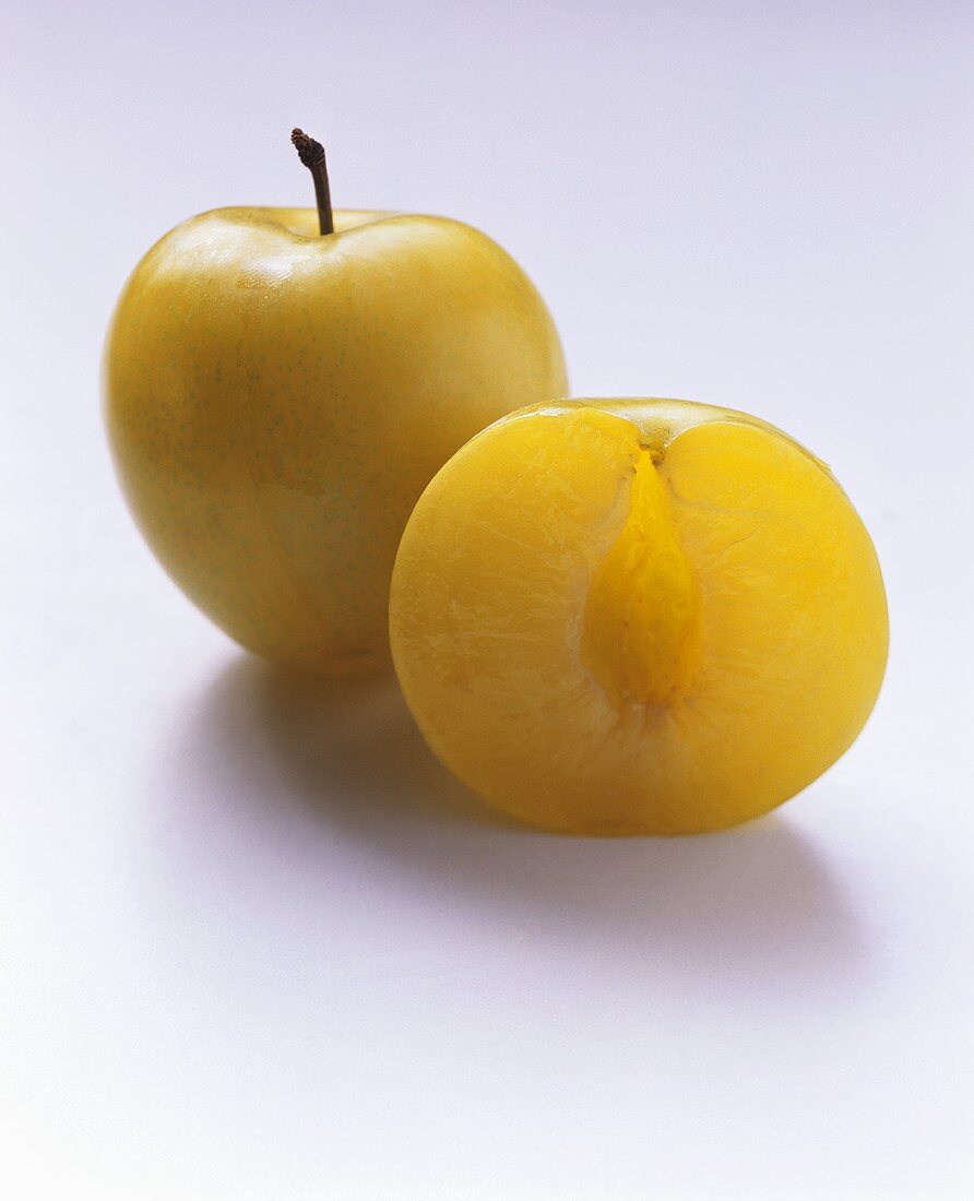 Yellow plum halves without stone; whole plum with stalk