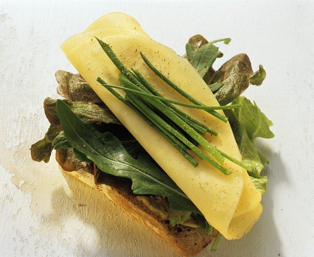 Cheese roll with lettuce leaves and chives