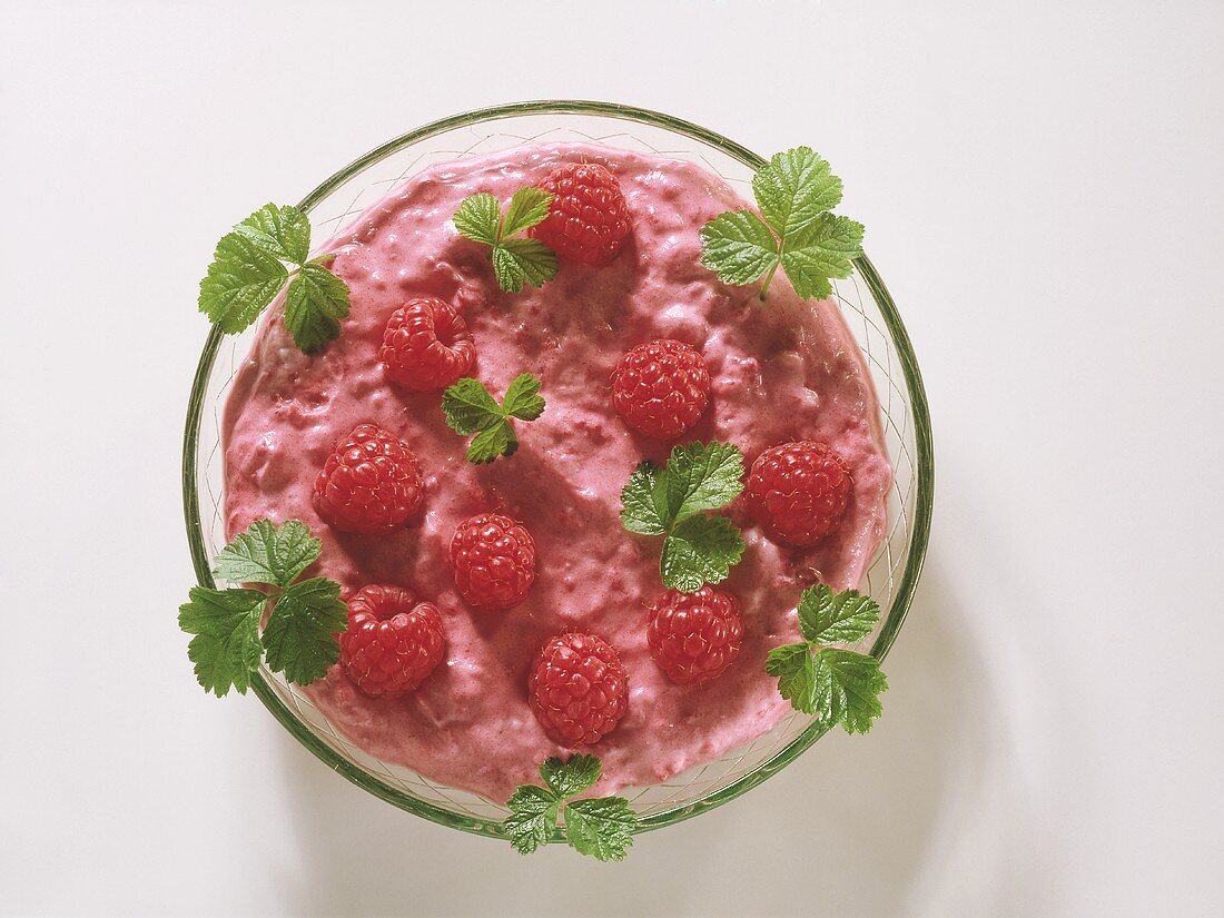 Raspberry mousse with fresh raspberries in glass bowl