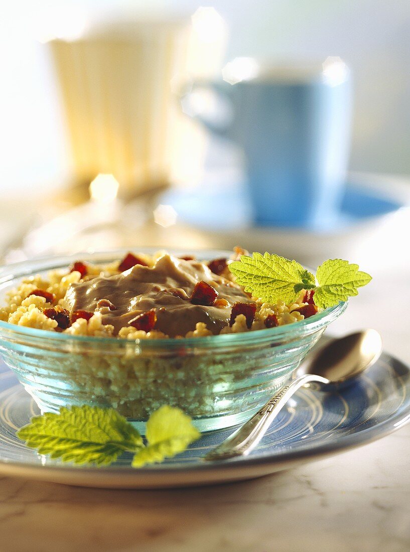 Millet muesli with date mousse & lemon balm in glass bowl