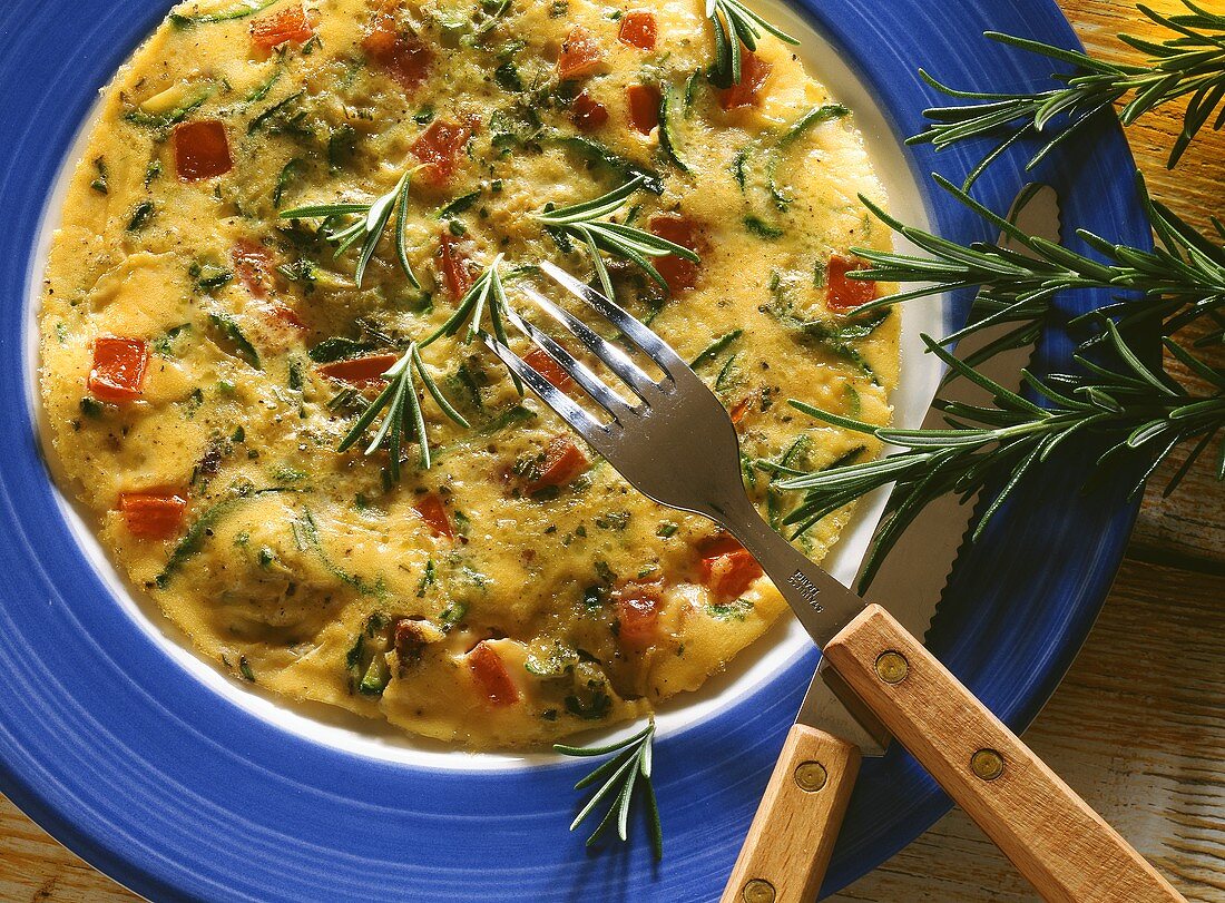 Rosemary omelette with courgette filling on plate with cutlery