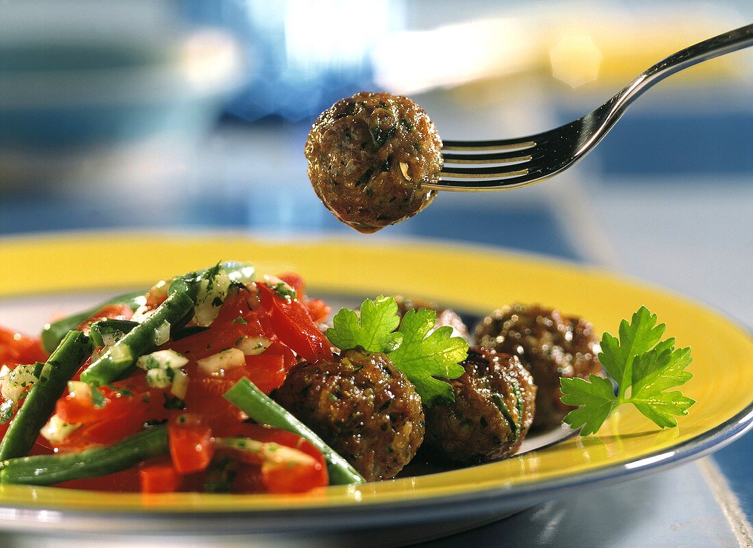 Meatballs with bean salad, red pepper and parsley